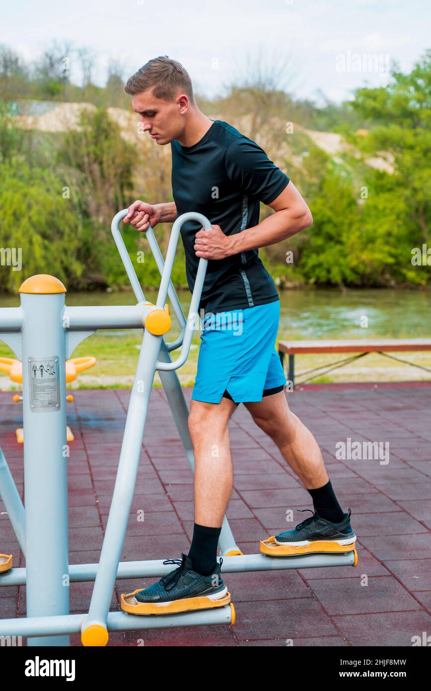 Fitness, sport, exercice, entraînement et concept de style de vie - jeune  homme faisant des jambes exercice sur la gazelle machine d'exercice dans le  parc d'été Photo Stock - Alamy