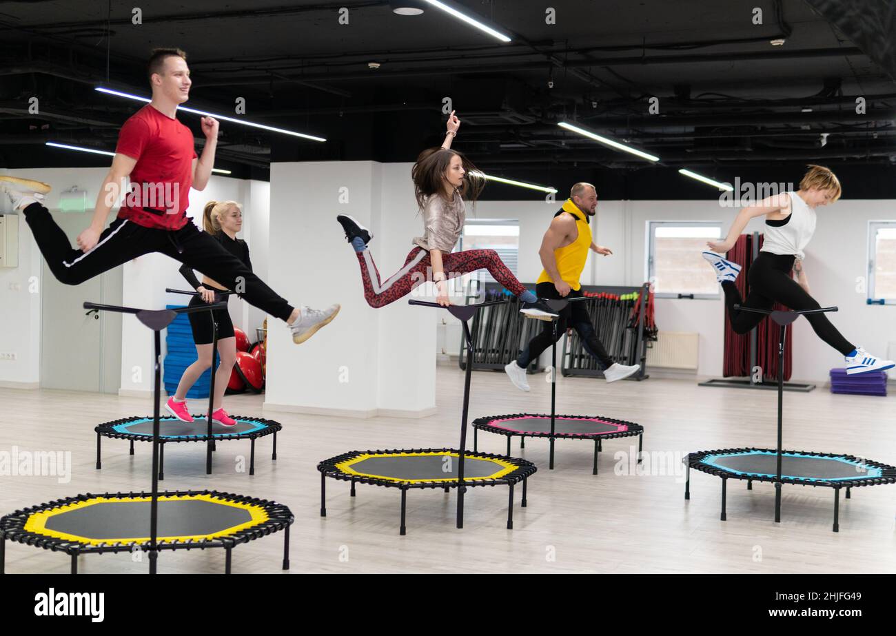 Groupe de femmes et d'hommes sur un trampoline de sport, entraînement de  fitness, vie saine - un concept trampoline groupe batut fille en bonne santé,  pour l'équipe de forme de l'escoupe Photo