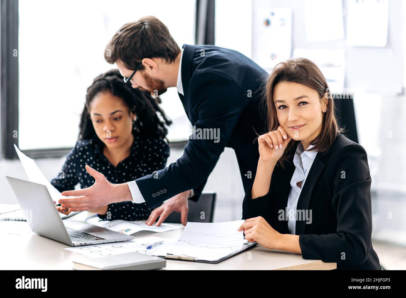 Remue-méninges d'entreprise.Une équipe d'affaires multiraciale créative et réussie, travaillant sur un projet d'entreprise, en démarrage, dans un bureau moderne.Femme intelligente d'affaires regardant la caméra, souriante amicale Banque D'Images