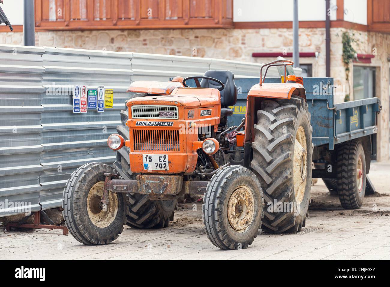 Side, Turquie - 22 janvier 2022 : le vieux tracteur orange de la marque Turk Fiat 640 est stationné dans la rue par une chaude journée d'été sur fond de bui Banque D'Images
