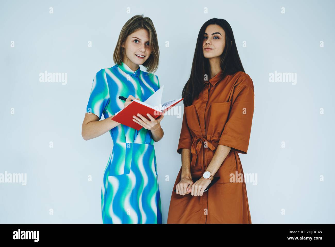 Des amies debout avec un ordinateur portable et une tablette Banque D'Images