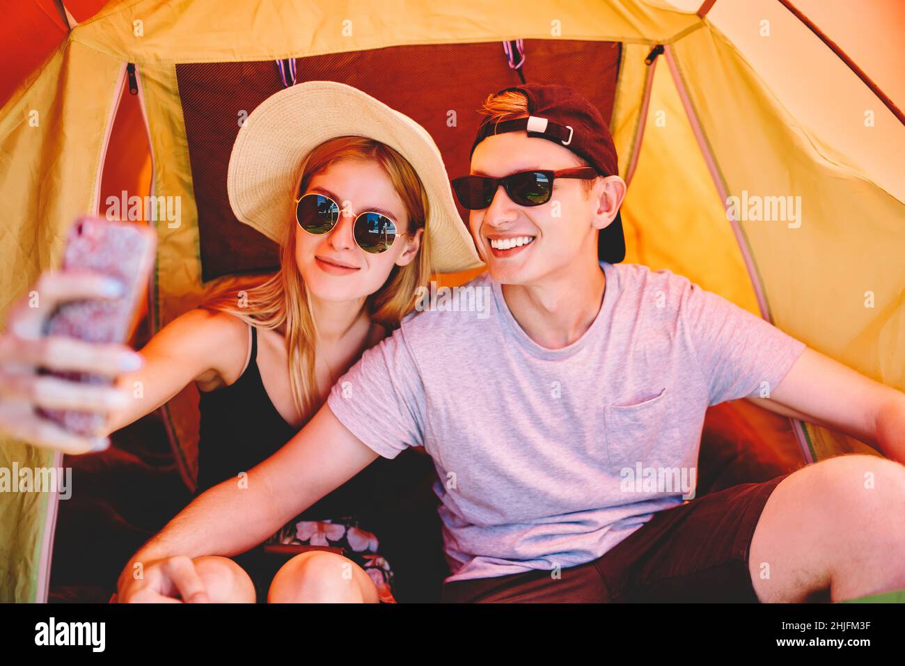 Couple de voyageurs prenant le selfie dans une tente de camping Banque D'Images