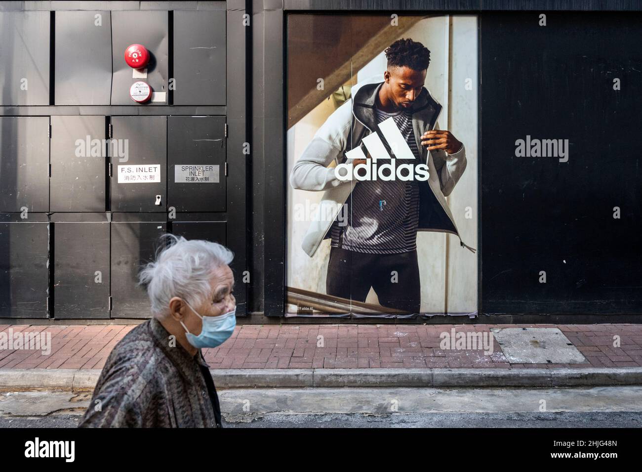 Un piéton passe devant le magasin Adidas de la marque multinationale allemande de vêtements de sport à Hong Kong. Banque D'Images