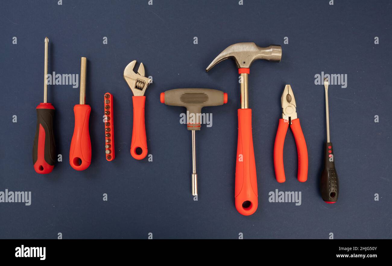 Outil de travail sur fond bleu.Nouvel ensemble d'outils à main avec poignée en caoutchouc rouge pour la réparation et la construction, pose à plat Banque D'Images