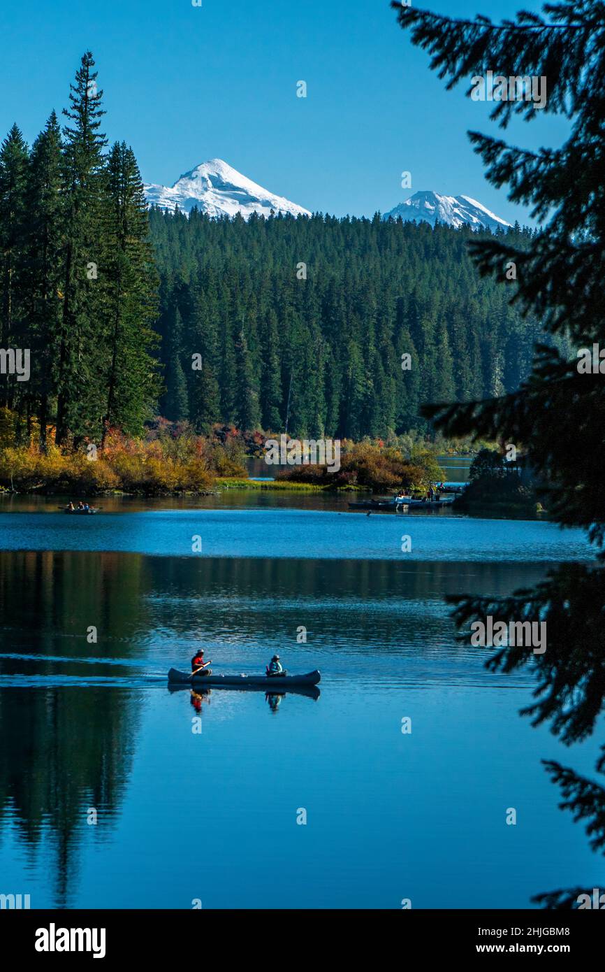 Canoë sur l'eau froide et claire du lac Clear du centre de l'Oregon avec les trois Sœurs en arrière-plan. Banque D'Images