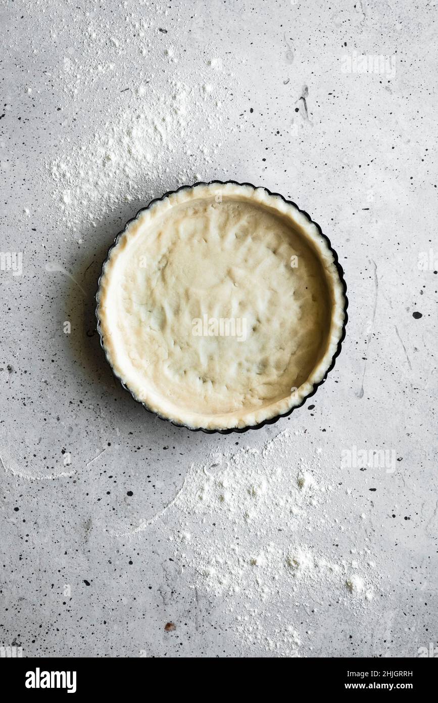 Une coquille de tarte non cuite sur une surface en pierre Banque D'Images