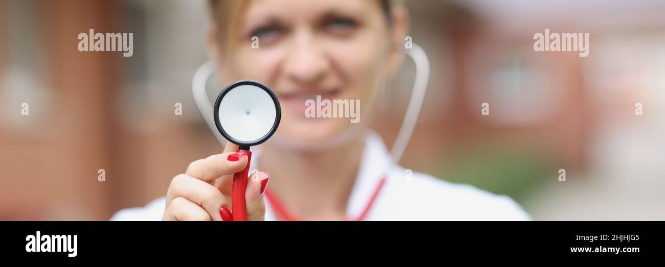 Portrait of smiling female doctor holding stethoscope Banque D'Images