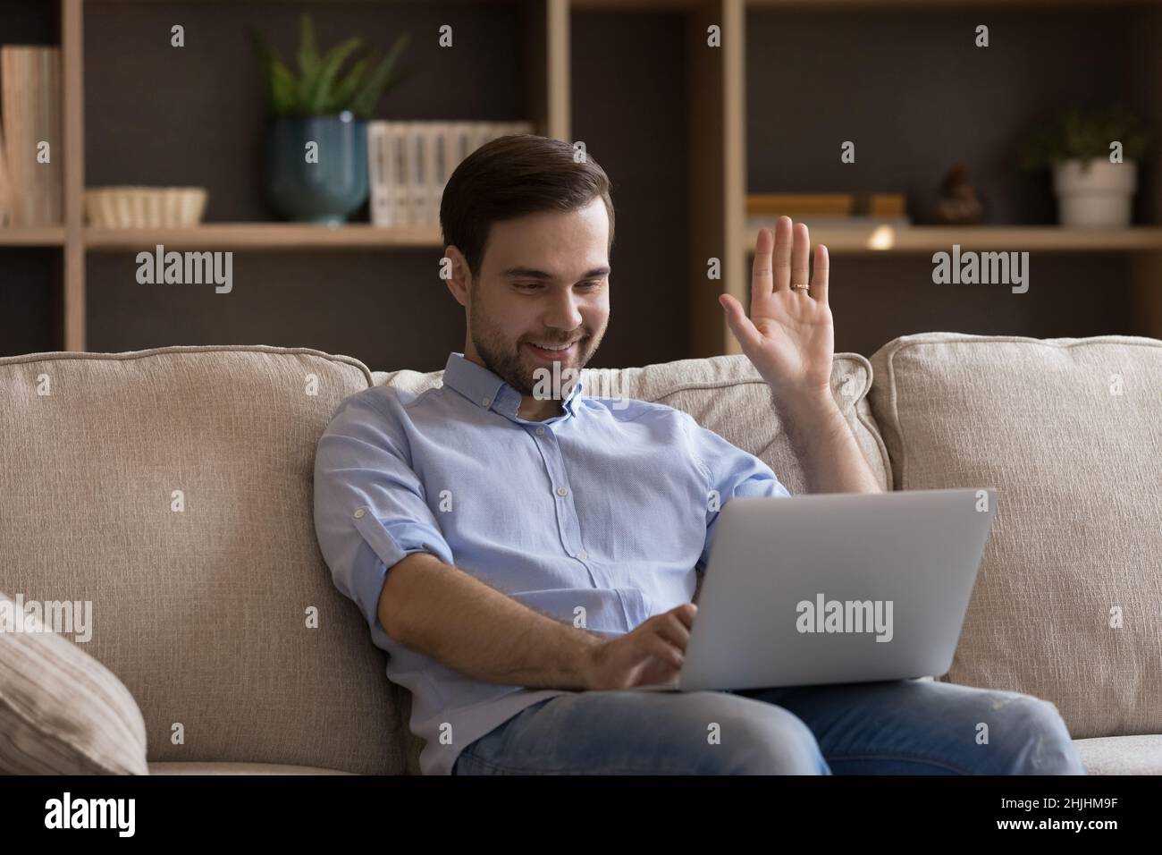 Homme joyeux du millénaire qui commence une conversation par appel vidéo. Banque D'Images