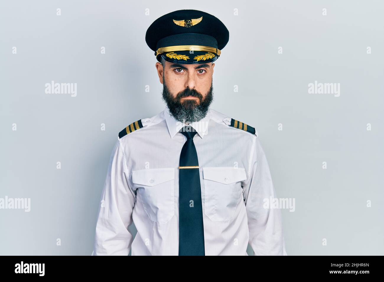 Jeune homme hispanique portant l'uniforme pilote d'avion déprimé et s'inquiète de la détresse, pleurant en colère et peur. Expression triste. Banque D'Images