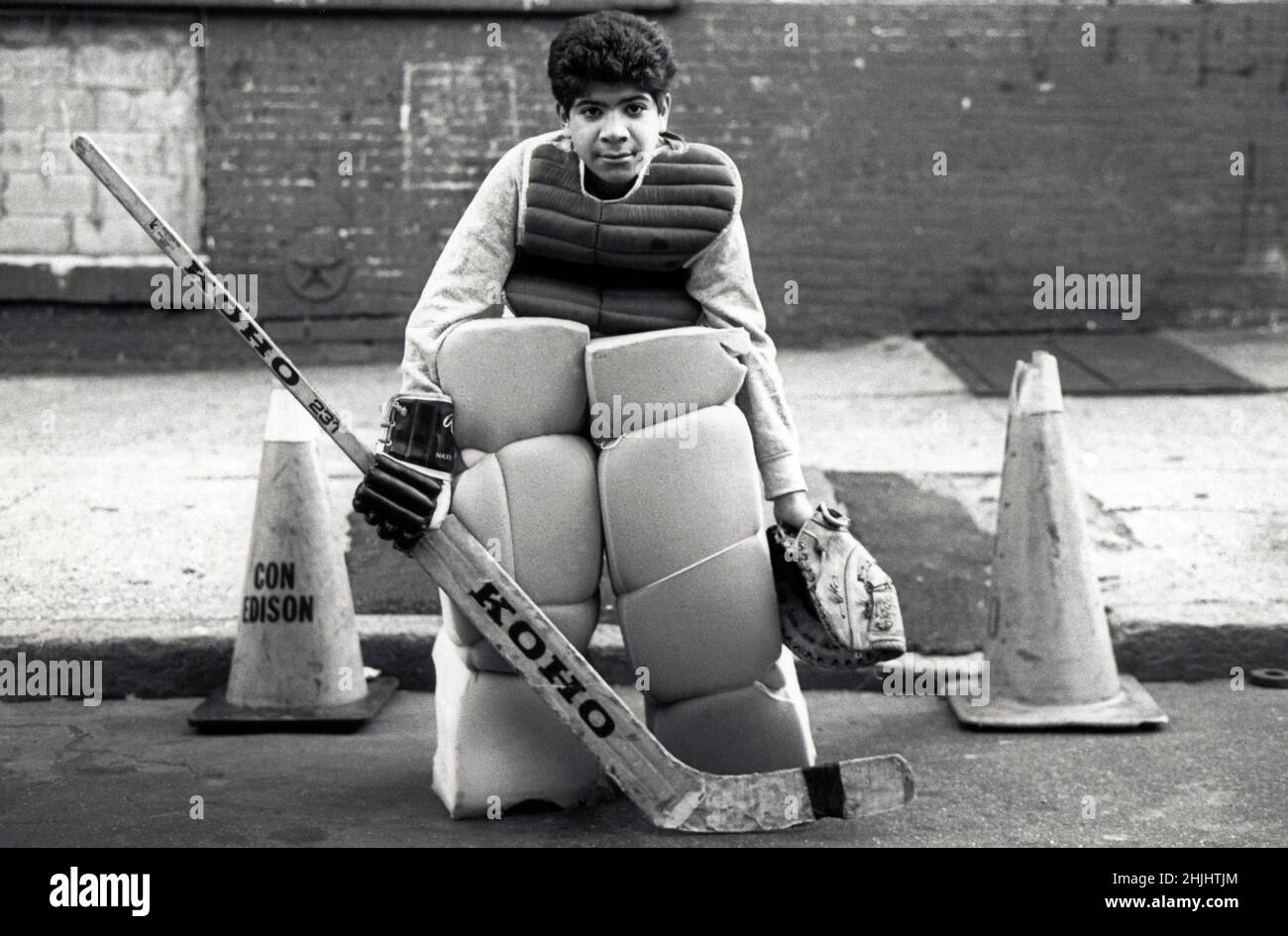 Un adolescent jouant du gardien de but sur son équipe de hockey de rue.Il porte des équipements à petit budget faits maison. Banque D'Images