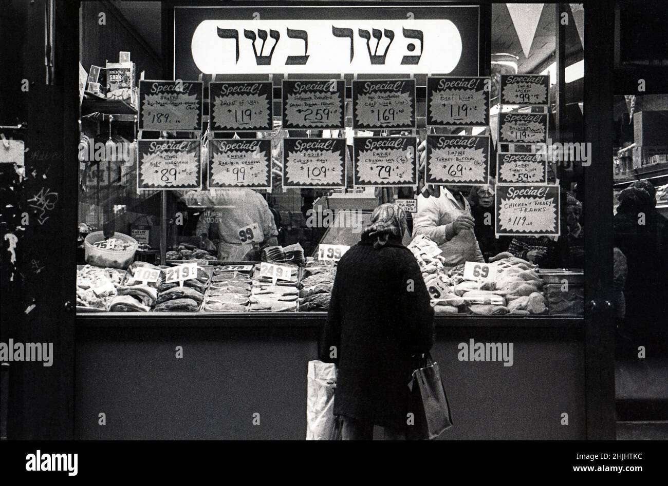 Photos du milieu des années 1970 d'une femme juive faisant du shopping dans une boucherie casher sur Brighton Beach avenue à Brighton Beach, Brooklyn, New York. Le signe hébreu dit viande de casher. Banque D'Images