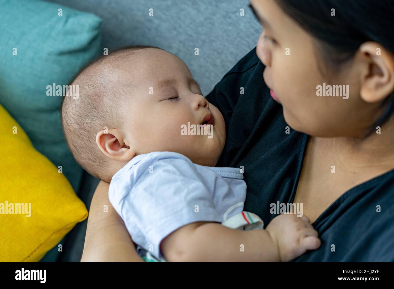 Bébé adorable dormant sur la main de sa mère Banque D'Images