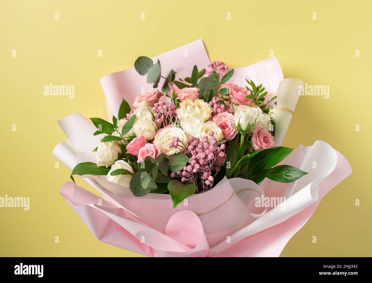 bouquet coloré de fleurs de roses mixtes sur fond jaune Banque D'Images