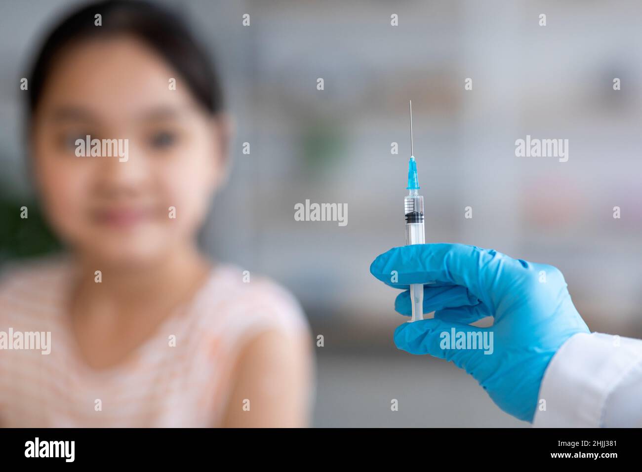 Médecin méconnaissable qui fait la vaccination d'un enfant asiatique Banque D'Images