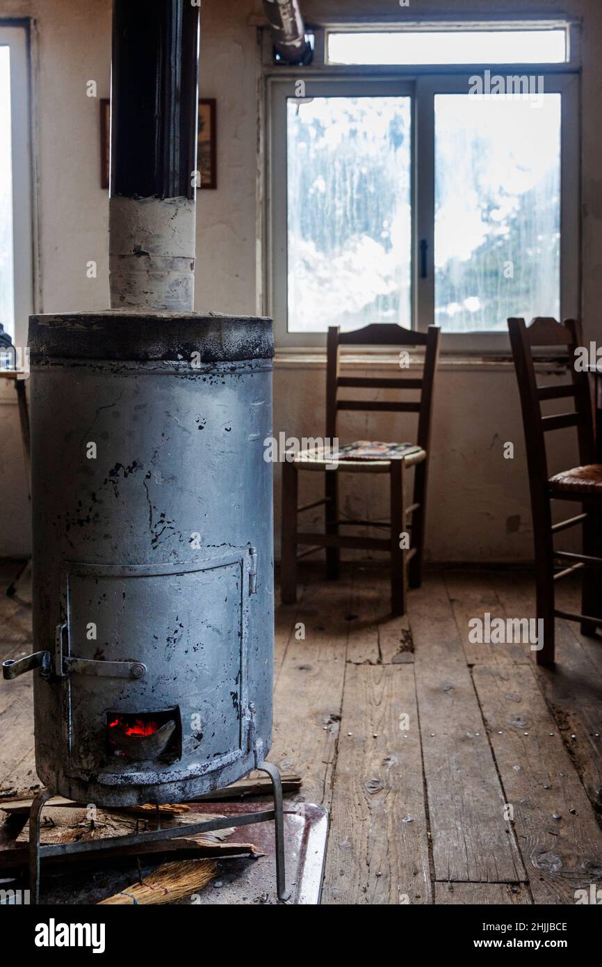 Ancien poêle en métal dans une ancienne maison traditionnelle avec parquet, dans la région montagneuse d'Agrafa, près de la ville de Karpenisi, Grèce, Europe. Banque D'Images