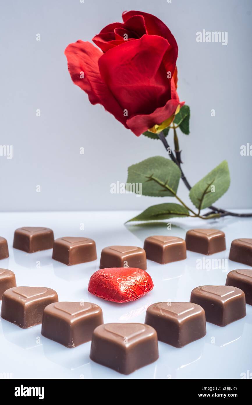 Helsinki / Finlande - 29 JANVIER 2022 : gros plan des confiseries au chocolat en forme de coeur, et des roses rouges sur fond blanc vif. Banque D'Images