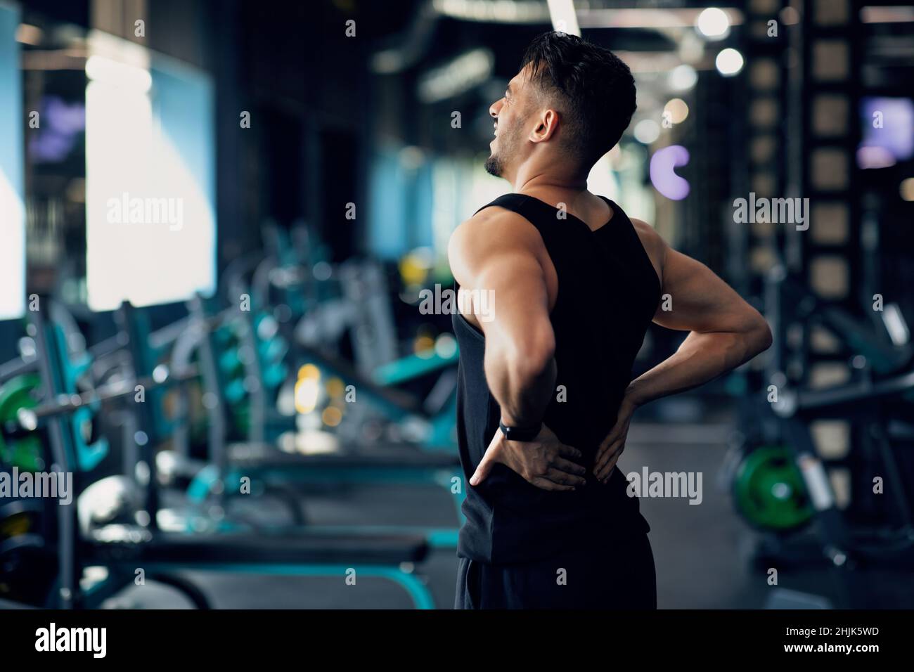 Portrait du jeune bodybuilder arabe souffrant de douleurs dans le bas du dos à la salle de gym Banque D'Images