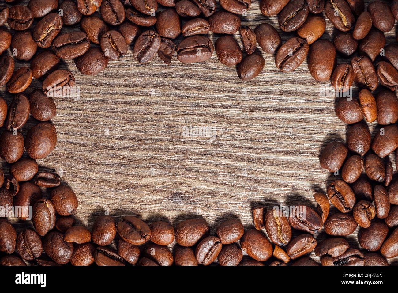 Grains de café rôtis sur une table en bois brun foncé avec espace de copie.Vue de dessus sur les grains de café sur fond en bois. Banque D'Images