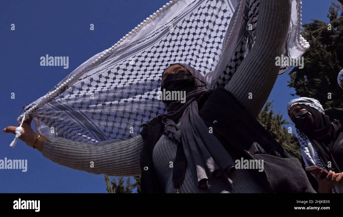 JÉRUSALEM, ISRAËL - JANVIER 30 : une bédouine vêtue d'un masque tient une héaddress arabe traditionnelle keffiyeh lors d'une manifestation devant le bureau du premier ministre israélien contre le contrôle foncier d'Israël dans le désert du Néguev et pour exiger la légalisation de villages bédouins non reconnus le 30 janvier 2022 à Jérusalem, en Israël.Crédit : Eddie Gerald/Alay Live Banque D'Images