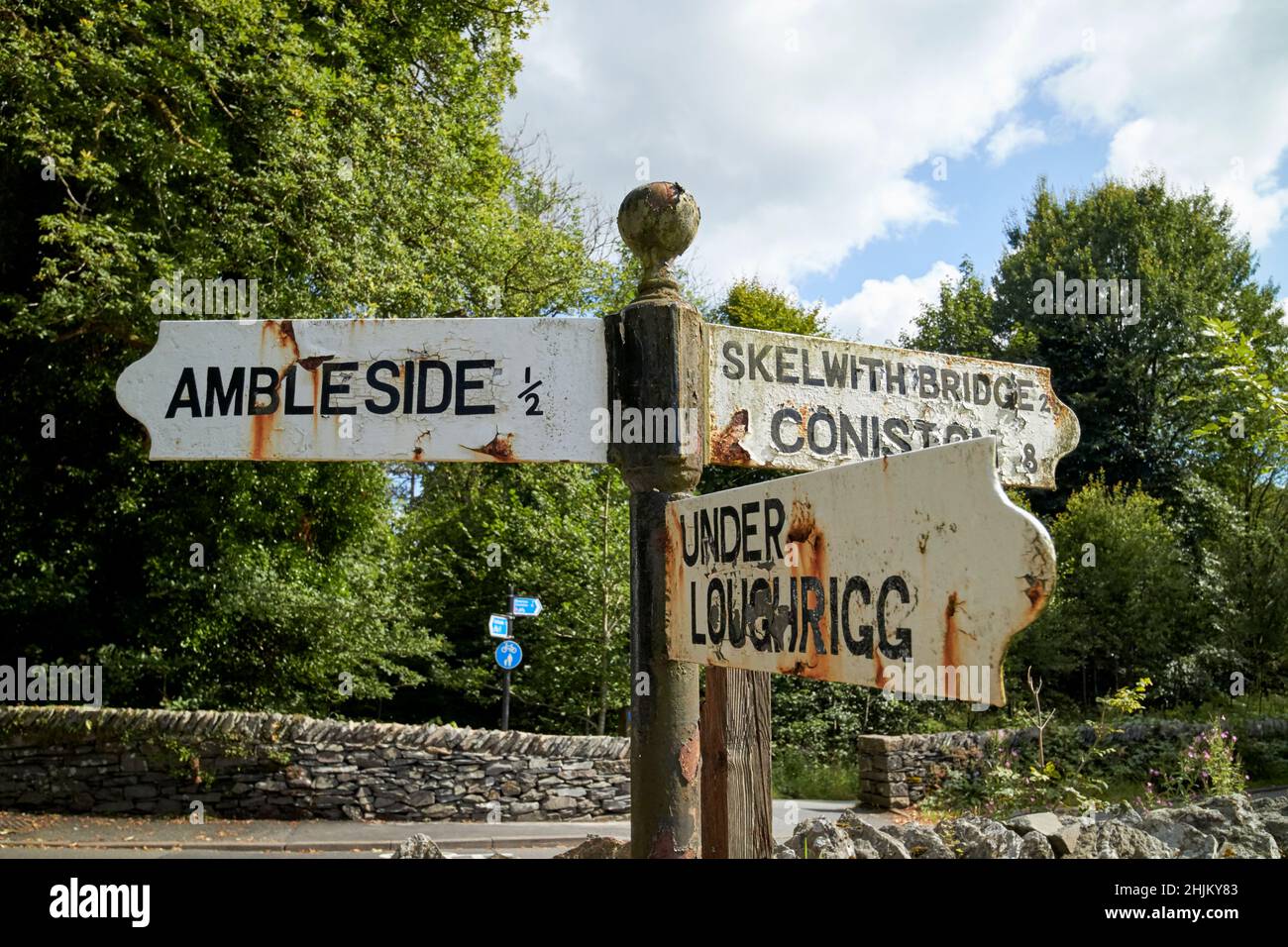 vieux panneaux de direction peints en blanc pour ambleside sous le pont de loughrigg skelwith et coniston lake district, cumbria, angleterre, royaume-uni Banque D'Images