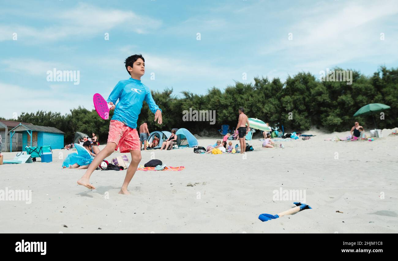 Un garçon jouant à des jeux de plage sur la plage de West Wittering, West Sussex, Royaume-Uni Banque D'Images