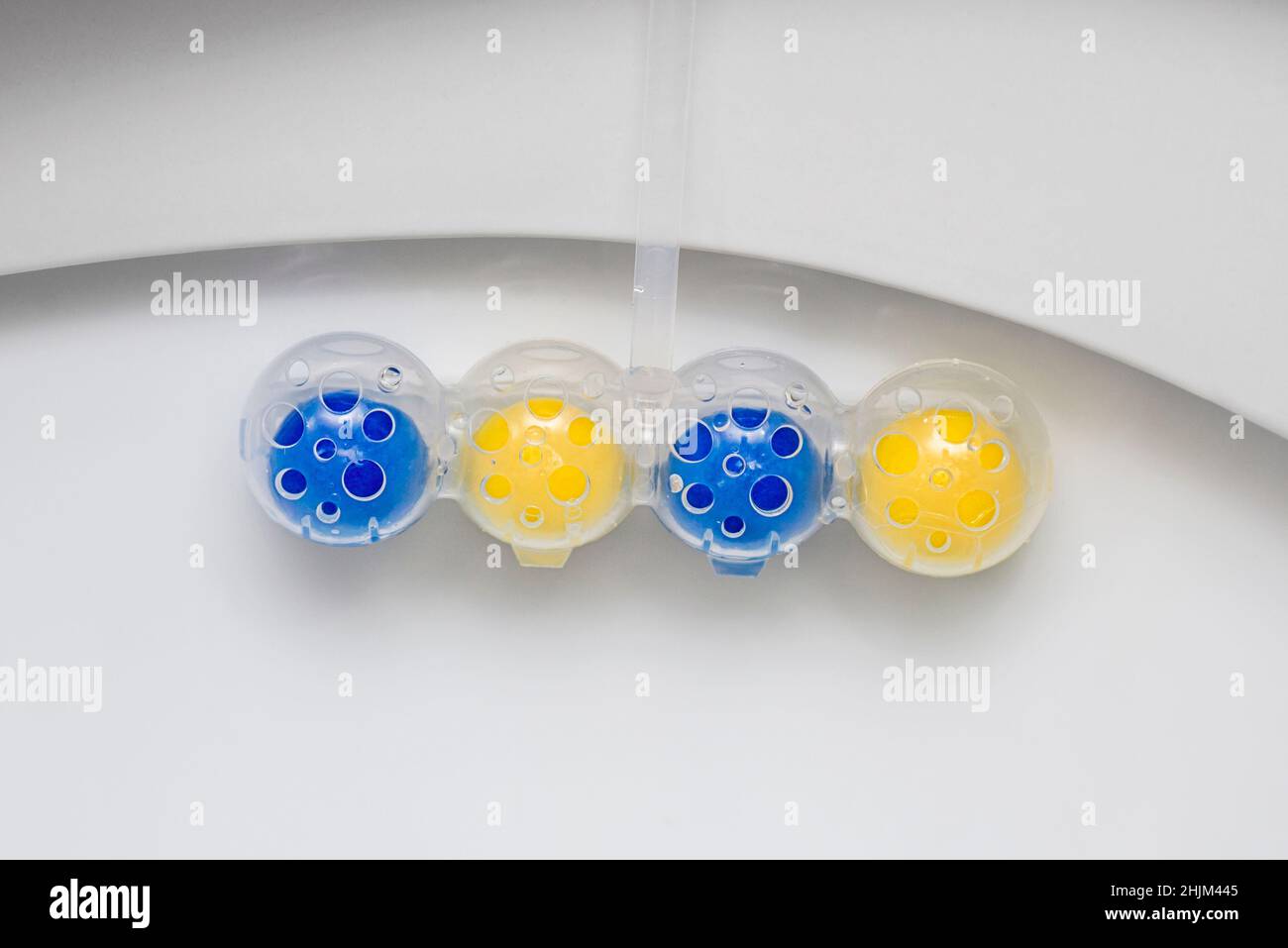 Nettoyez le bol des toilettes avec des boules nettoyantes et rafraîchissantes.Boules multicolores de nettoyant pour cuvette de toilette. Banque D'Images