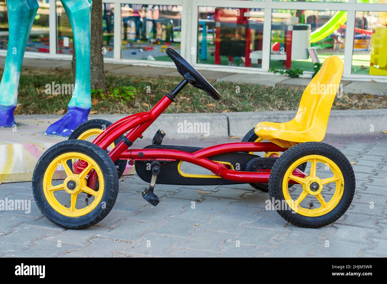 Vélo à quatre roues sur la chaussée du parc.Karting à pédales pour enfants. Banque D'Images