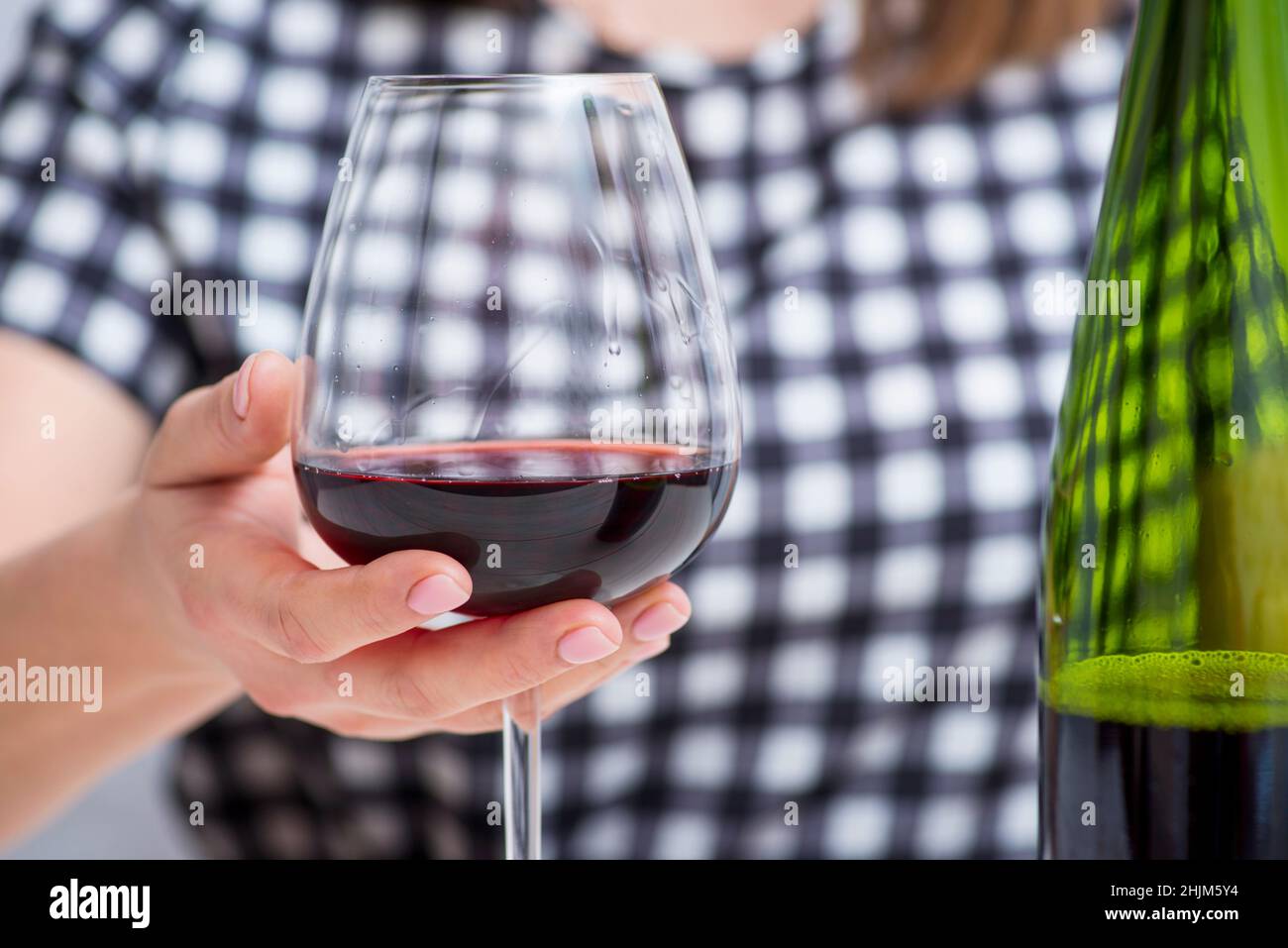 Femme tenant un verre de vin rouge.Femme qui boit de l'alcool. Banque D'Images