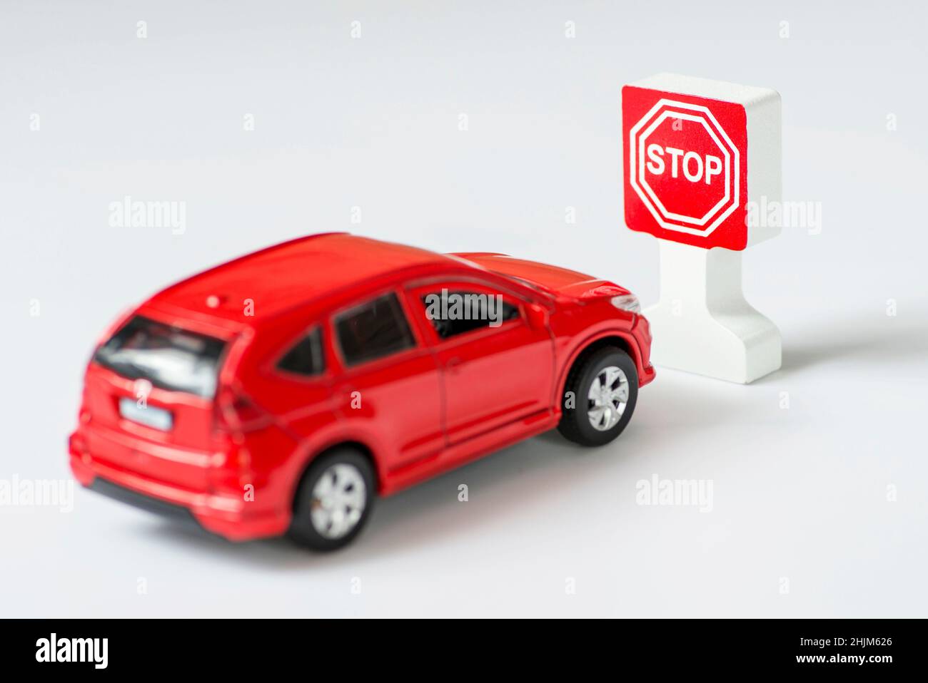 Un panneau indiquant une voiture et un arrêt sur fond blanc.Voiture