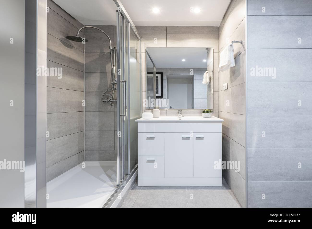 Salle de bains avec douche avec cloison en verre, miroir carré sans