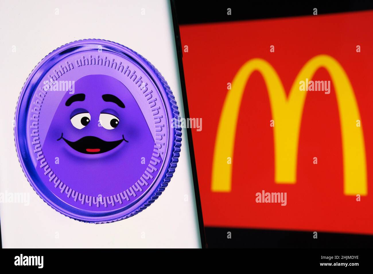 Pièce grimace visible sur l'écran du smartphone et logo McDonald's flou sur l'arrière-plan.Fausse pièce de monnaie.Stafford, Royaume-Uni, 30 janvier 2022. Banque D'Images