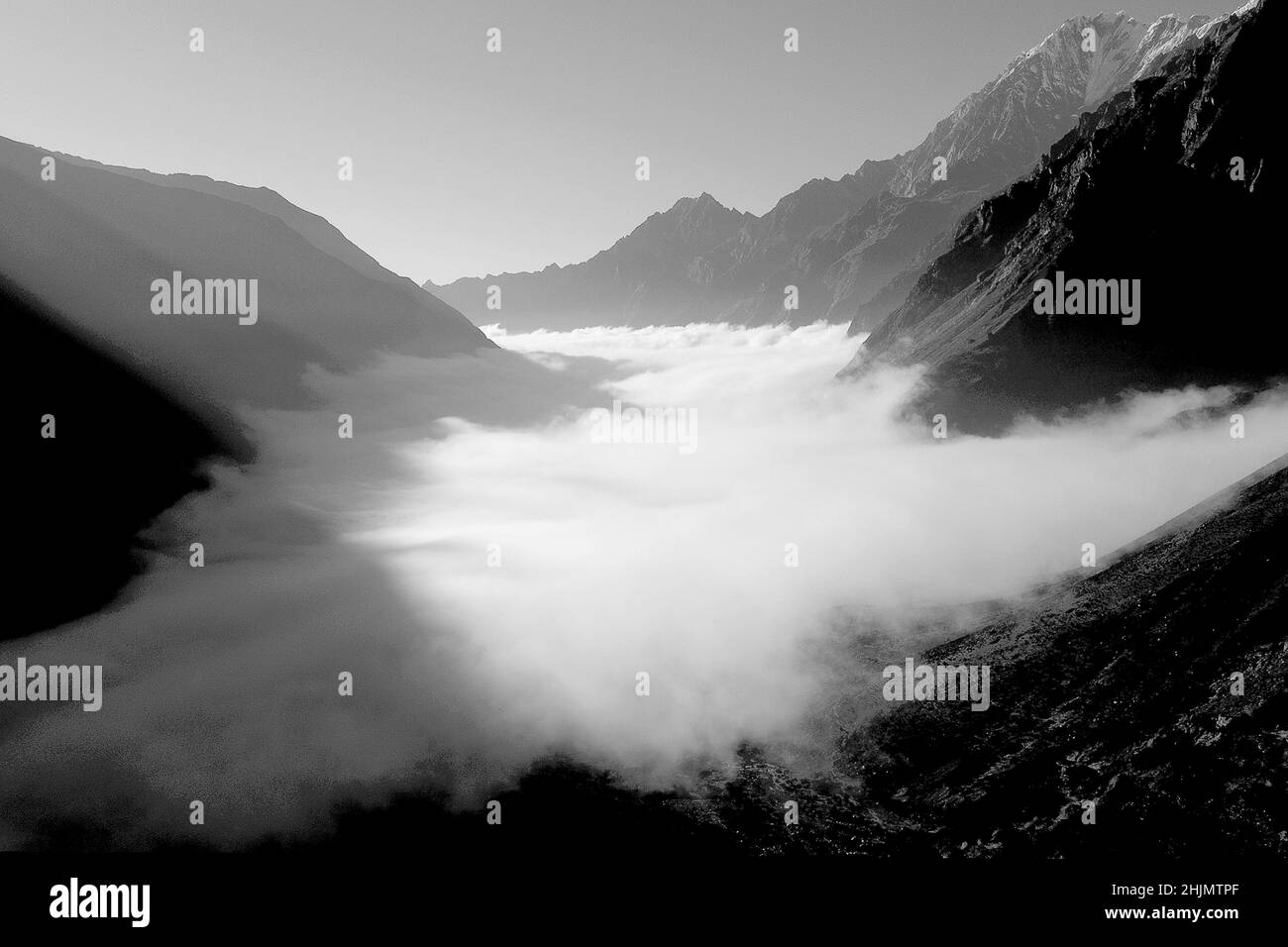 Photographie en noir et blanc d'une vallée de montagne, nuages de tempête et lumière du soleil, vallée de Langtang, Langtang, Himalaya, Népal, Asie, 2016. Banque D'Images