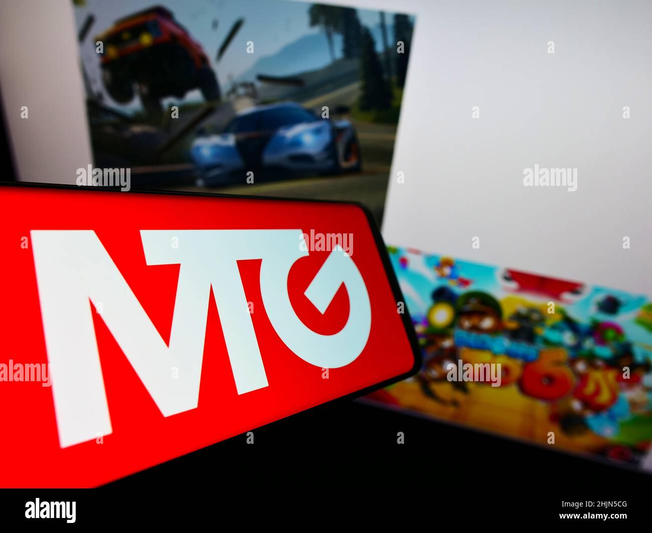 Téléphone mobile avec logo de la société suédoise Modern Times Group AB (MTG) sur écran en face du site web des entreprises.Concentrez-vous sur le centre de l'écran du téléphone. Banque D'Images