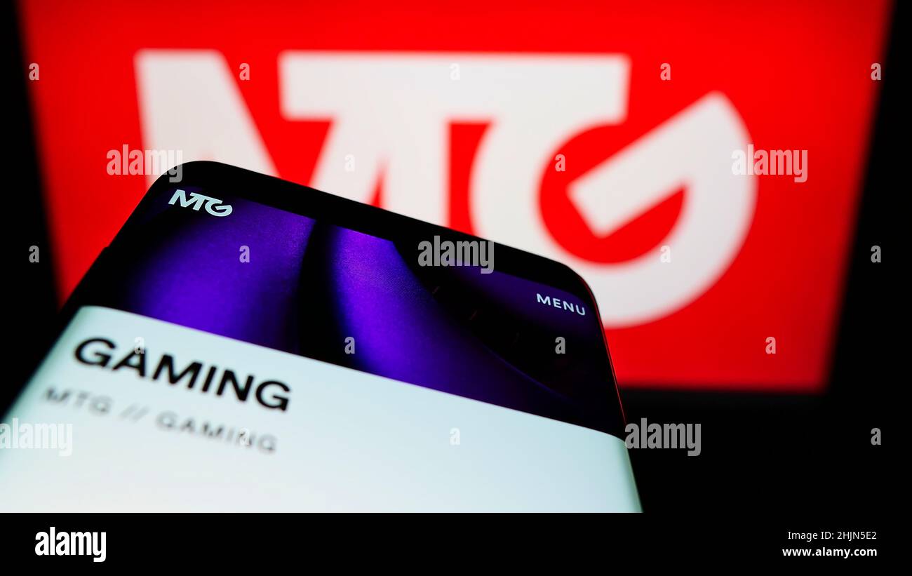 Smartphone avec le site Web de la société suédoise Modern Times Group AB (MTG) sur écran devant le logo de l'entreprise.Faites la mise au point dans le coin supérieur gauche de l'écran du téléphone. Banque D'Images