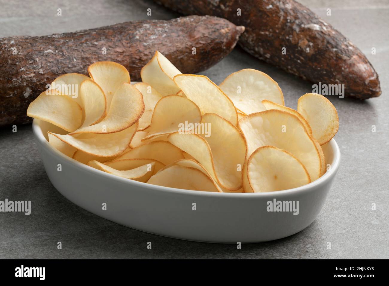 Bol avec frites de manioc gros plan et tuber ciré en arrière-plan Banque D'Images