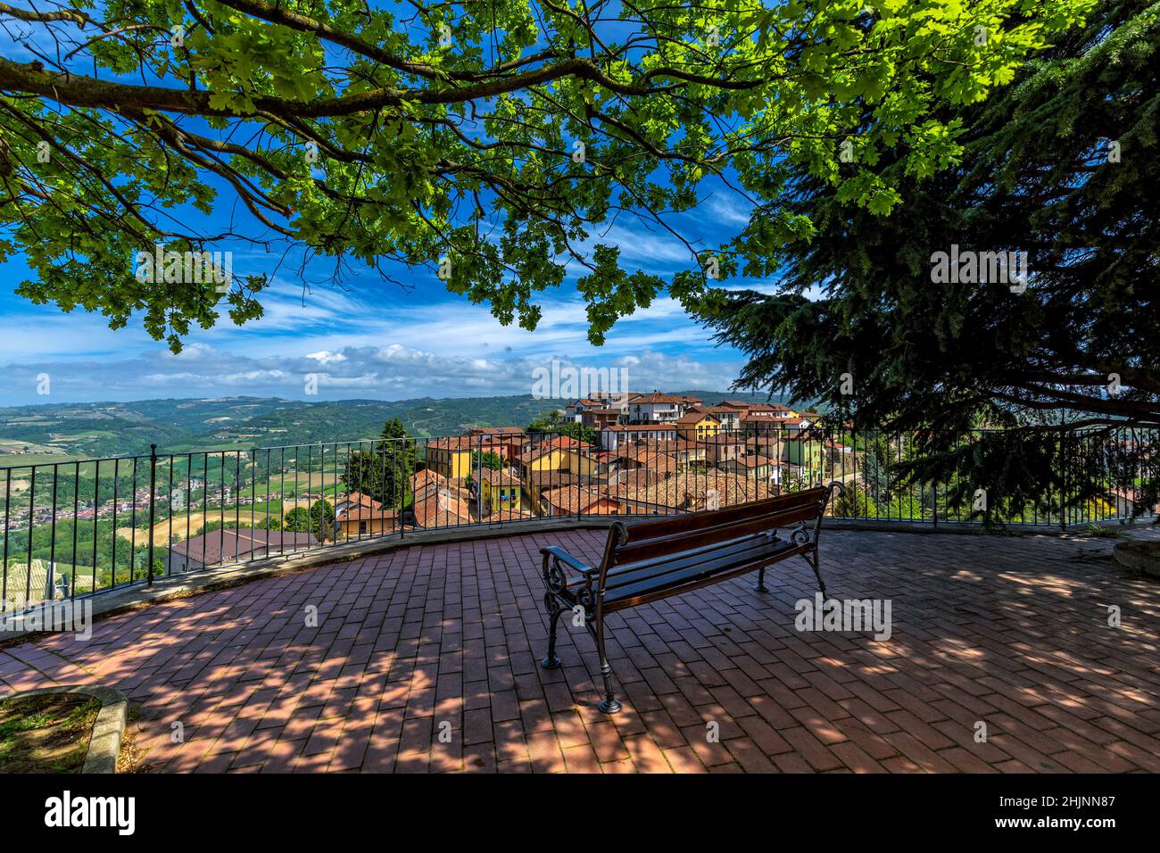 Banc sous les arbres au point de vue surplombant la petite ville de Diano d'Alba dans le Piémont, dans le nord de l'Italie. Banque D'Images