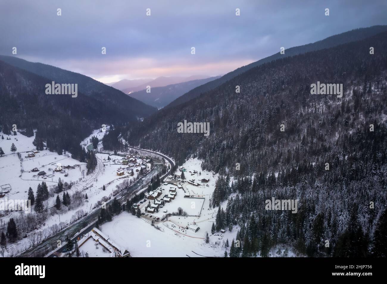Montagnes couvertes de forêt et de route dans la vallée.Temps d'hiver sombre et sombre. Banque D'Images