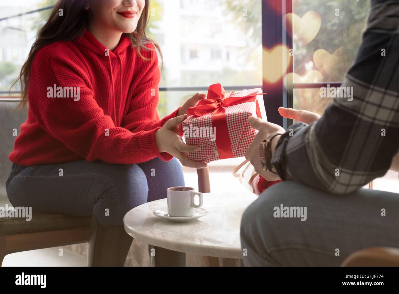 Concept de la Saint-Valentin.Un homme heureux et une femme amoureux se présentant des cadeaux les uns aux autres dans un café. Banque D'Images