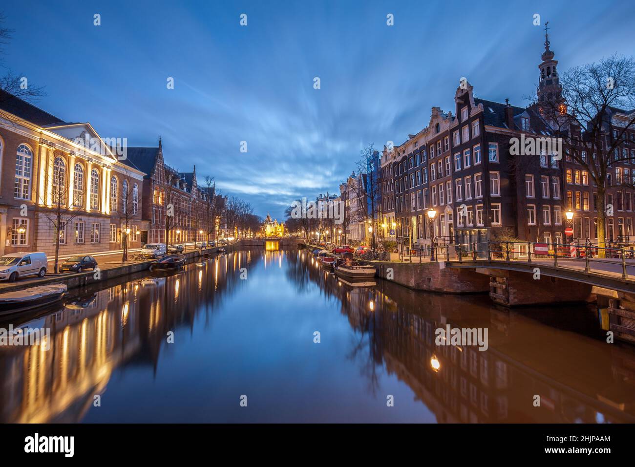 Le canal d'Amsterdam au lever du soleil les lumières de la rue et les bateaux amarrés Amsterdam Hollande Banque D'Images