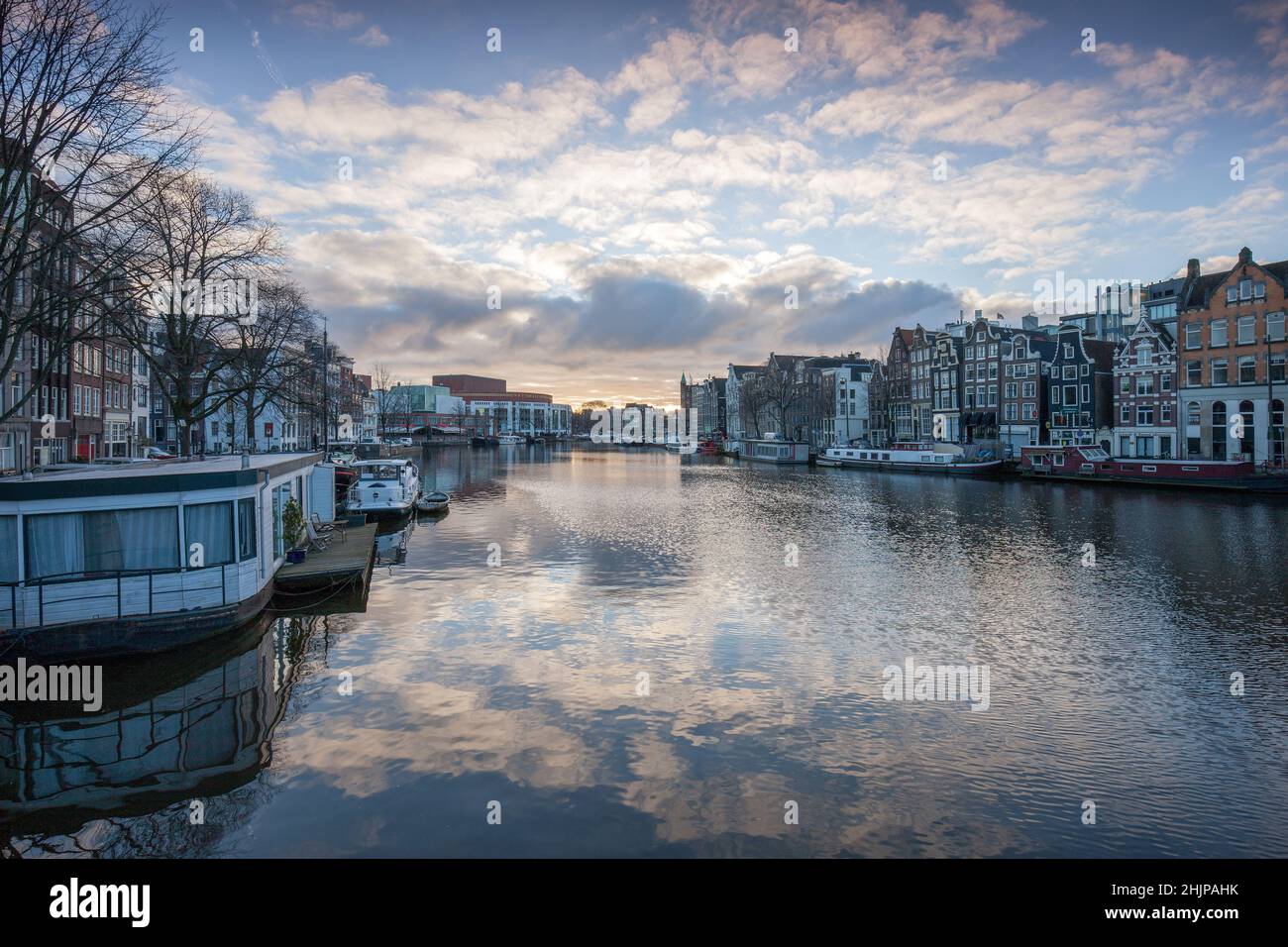 Vue sur le canal d'Amsterdam au lever du soleil avec des bateaux maison et des barges fluviales amarrées Amsterdam, Hollande des bateaux maison et des barges fluviales amarrées Amsterdam, Hollande Banque D'Images