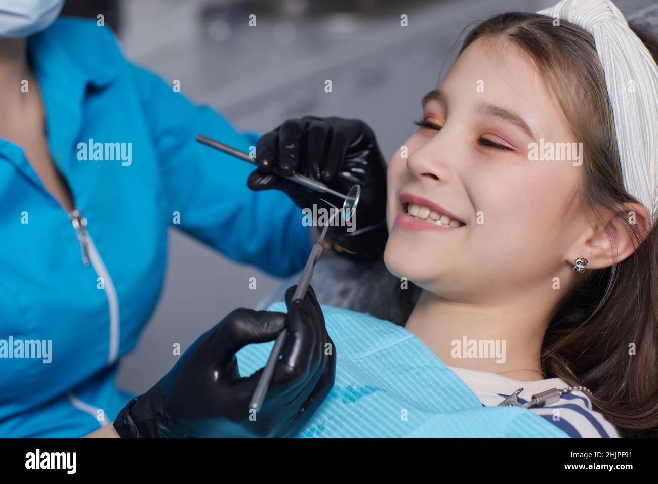 Le dentiste examine les dents du bébé de la petite fille, le traitement des dents du bébé, le dentiste tient un miroir dans ses mains, des caries dans un enfant Banque D'Images