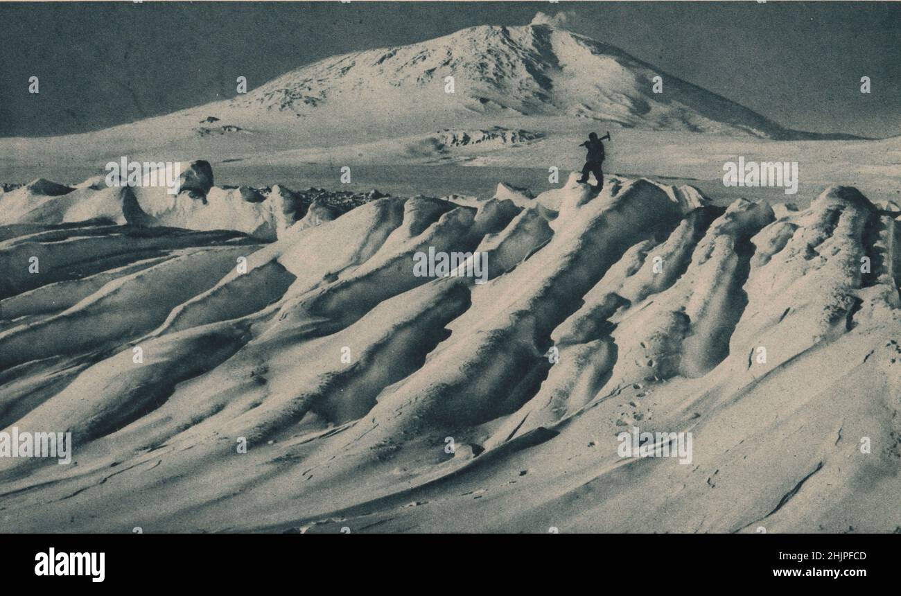Iceberg vu dans South Bay par la dernière expédition de Scott. Au loin se dresse le cône enneigé et à bout de fumée du mont Erebus. Antarctique (1923) Banque D'Images