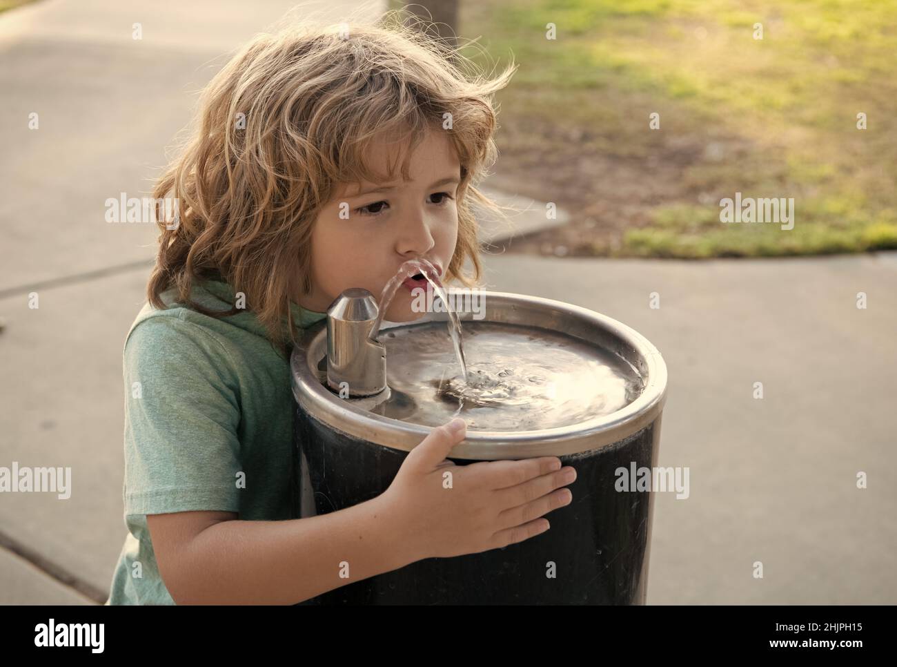 Solution de rafraîchissement. Un enfant assoiffé boit de l'eau de la fontaine. Soif désaltérante Banque D'Images