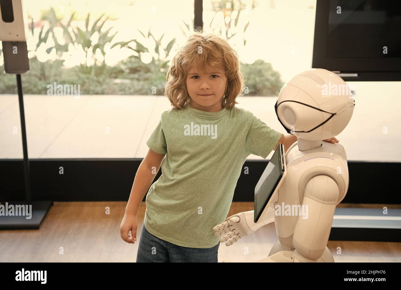 assistant de kid et de robot avec écran d'information dans le masque de protection. robot pandémie future. robot fournir assistance à l'enfant. technologie humanoïde. a Banque D'Images