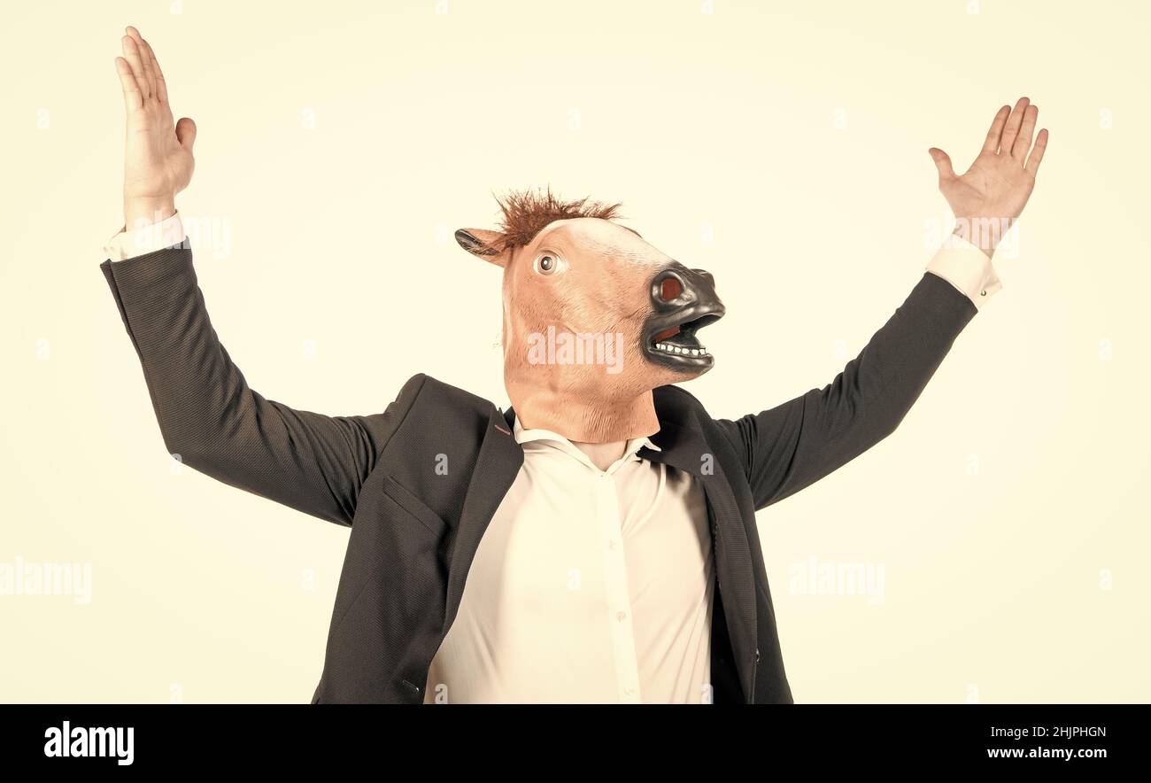 Homme d'affaires dur porter masque de tête de cheval bizarre en tenue isolée sur blanc, cheval de travail Banque D'Images