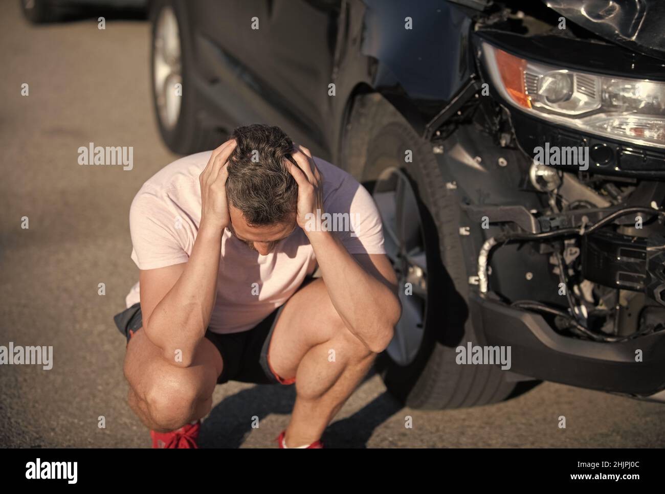 accident de voiture. conducteur frustré après un accident de la route. homme avec auto cassé sur la route. Banque D'Images