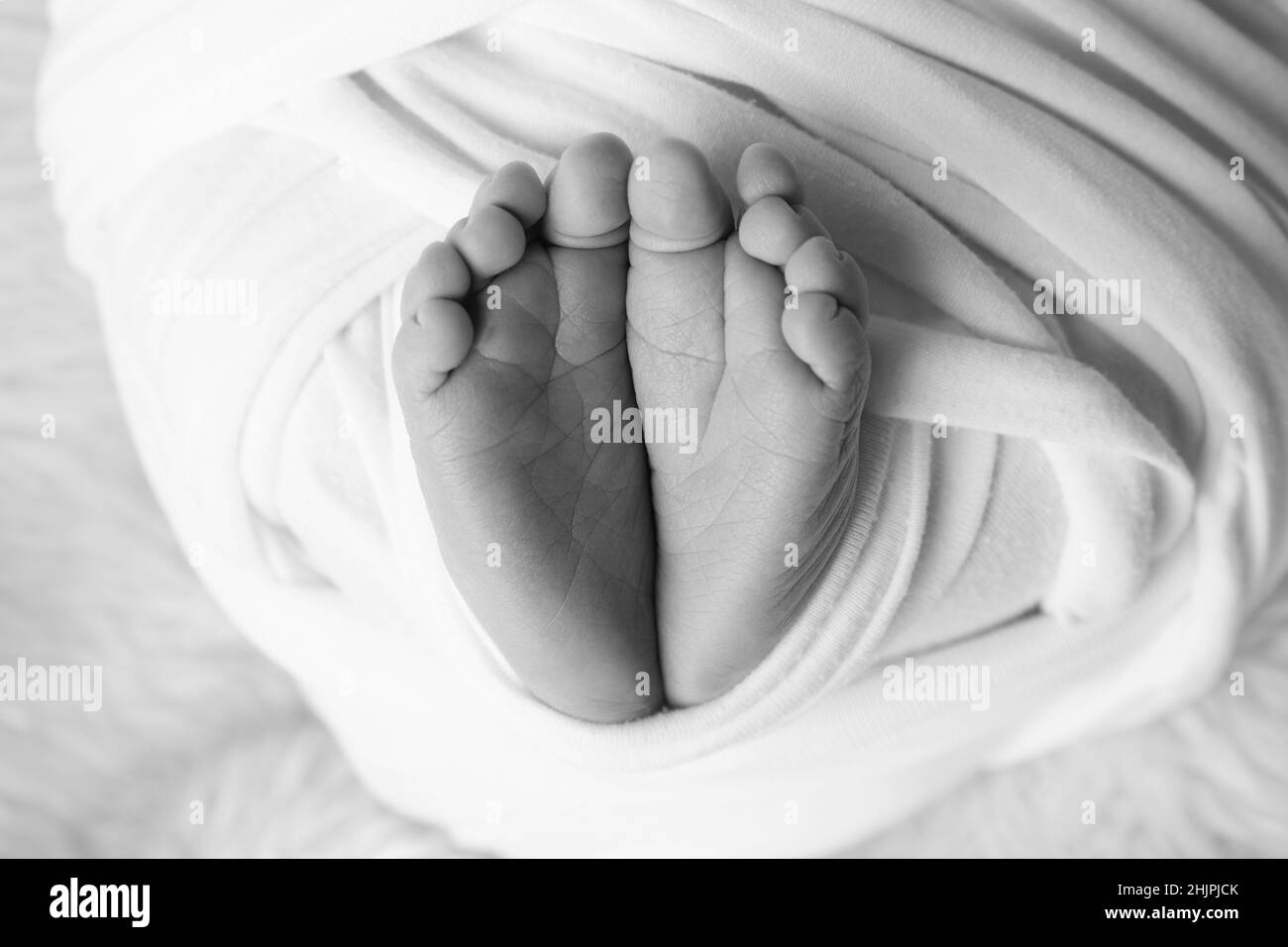 Le pied minuscule d'un nouveau-né.Pieds doux d'un nouveau-né dans une couverture.Gros plan des orteils, des talons et des pieds d'un nouveau-né. Banque D'Images
