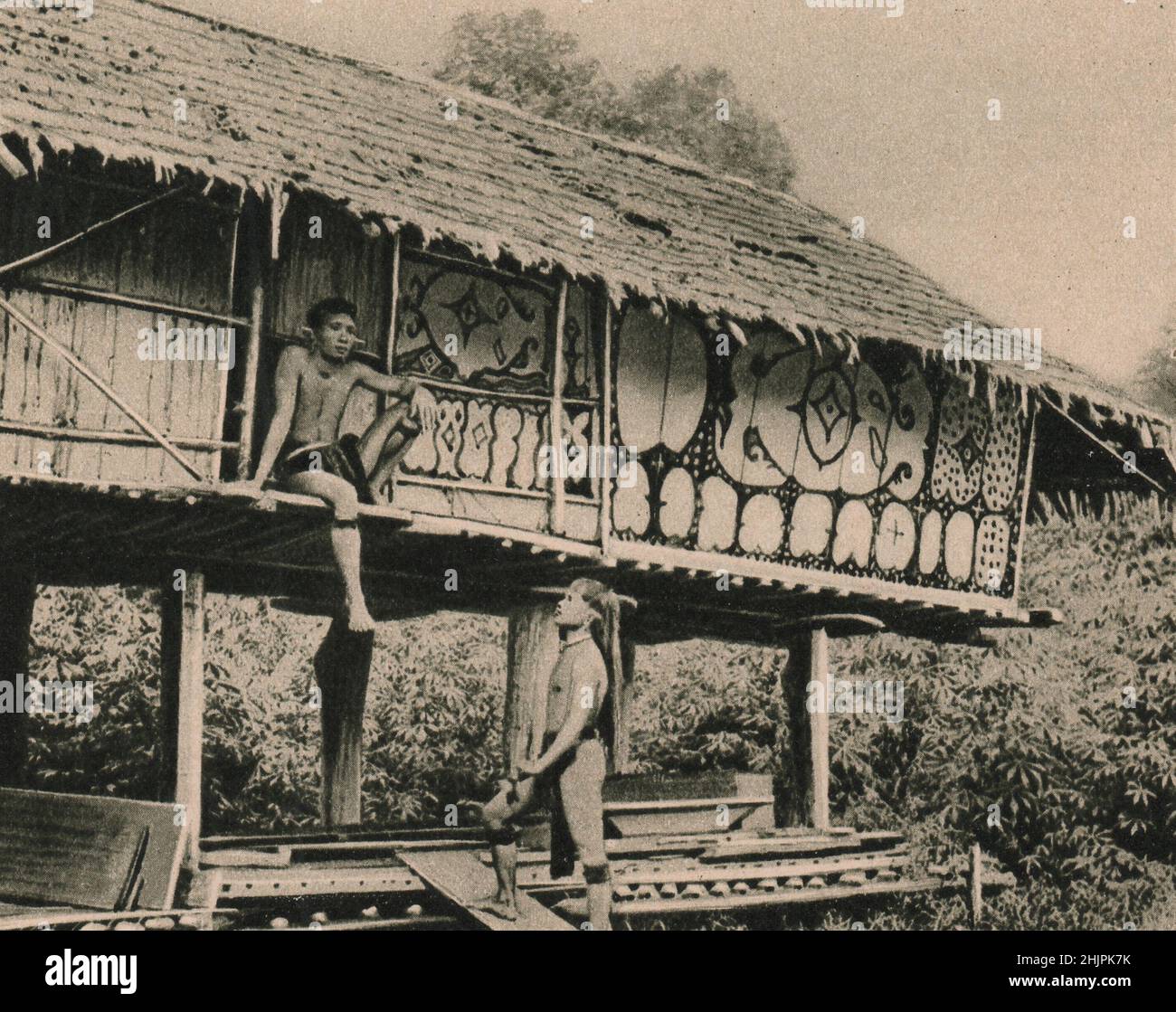 À côté de la longue maison, les indigènes construisent habituellement une grange commune de riz, souvent décorée comme ce spécimen de Kalimantan. Malaisie. Bornéo (1923) Banque D'Images