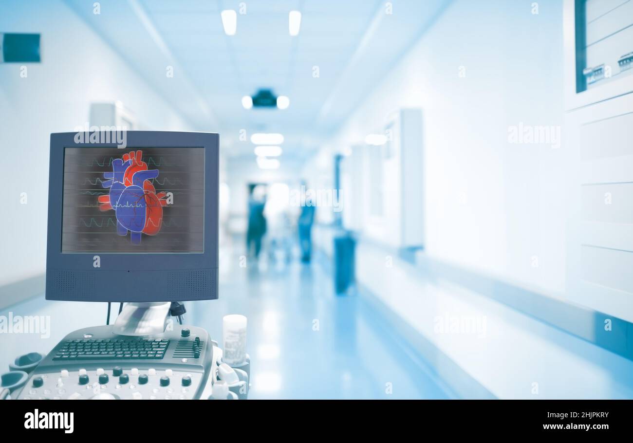 Equipement d'échographie avec image cardiaque sur l'écran dans le couloir des urgences avec des médecins en activité.Concept de soins d'urgence dans un hôpital avec coeur Banque D'Images