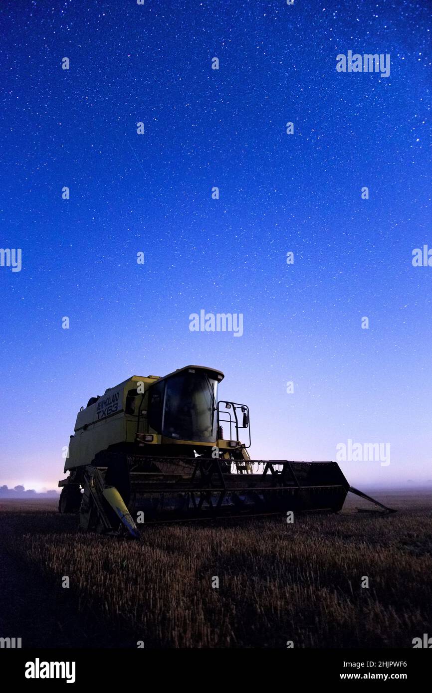 Moissonneuse-batteuse de nuit avec ciel étoilé  Norfolk Royaume-Uni Banque D'Images